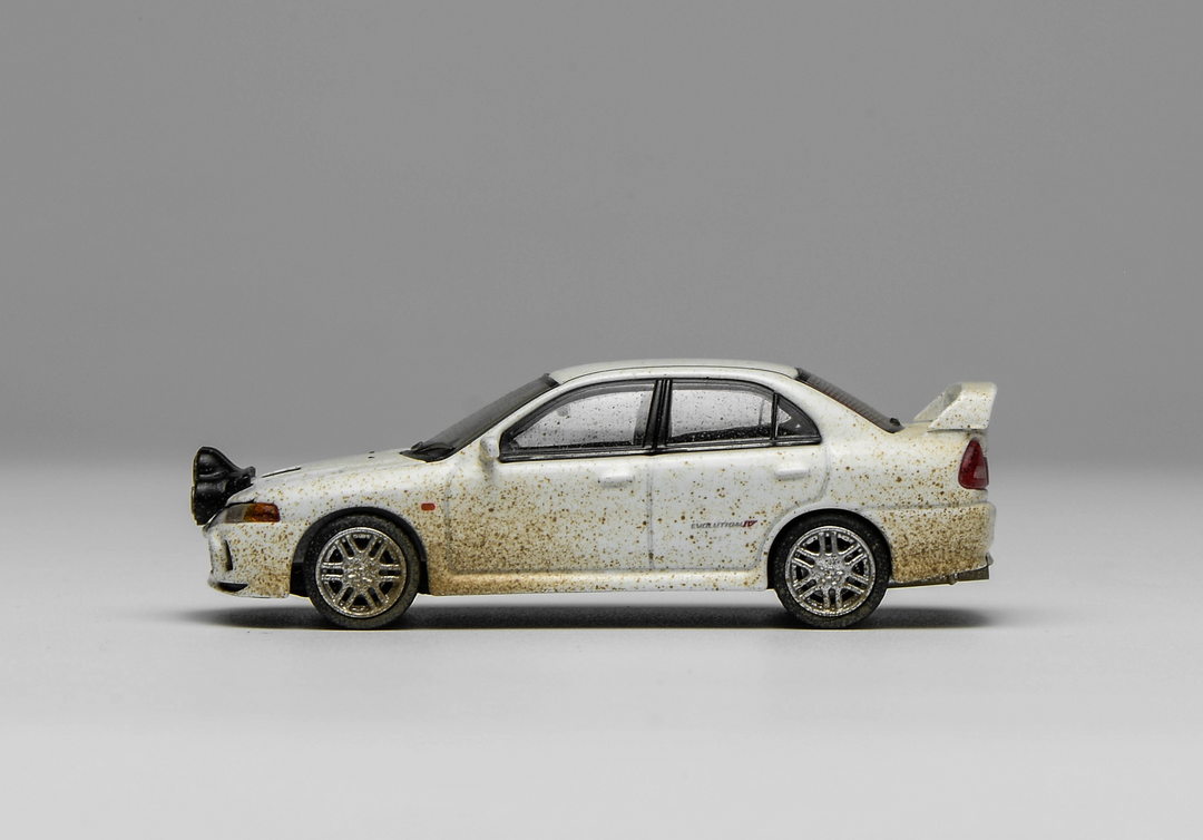 [Preorder] MOTORHELIX 1:64 Mitsubishi Lancer Evolution lV Muddy Version with Rally Light M64015